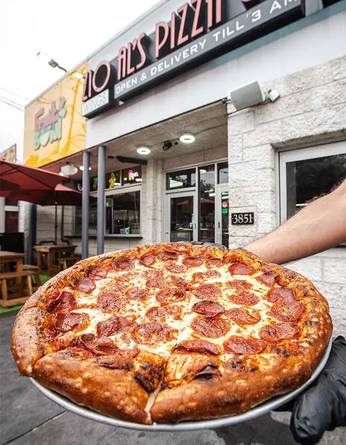Freshly made pizza, wings, and pasta served at Zio Al’s, a top pizza restaurant in DFW, open daily until 3 AM, offering delivery and catering.